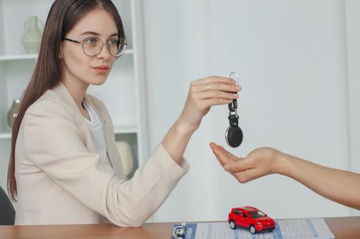 黒のストラップを渡す女性スタッフ 保険業,事務職,接客業の写真素材