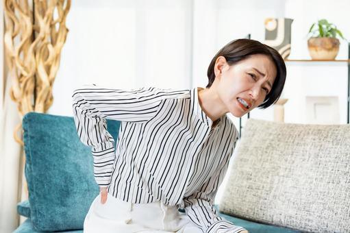 腰をおさえる女性 腰をおさえる女性 腰痛,ぎっくり腰,女性の写真素材