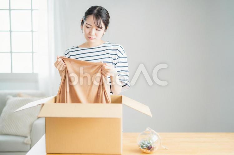 届いた商品に納得がいかない女性（不良品・返品） 不良品,返品,交換の写真素材