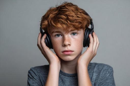ヘッドホンをした欧米人の男の子 ヘッドホンをした欧米人の男の子の写真