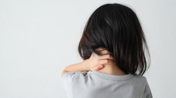 首を痛がる小学生の女の子 首を痛がる小学生の女の子の写真
