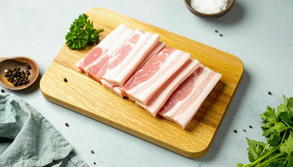 カッティングボードの上の豚バラ肉 カッティングボードの上の豚バラ肉の写真