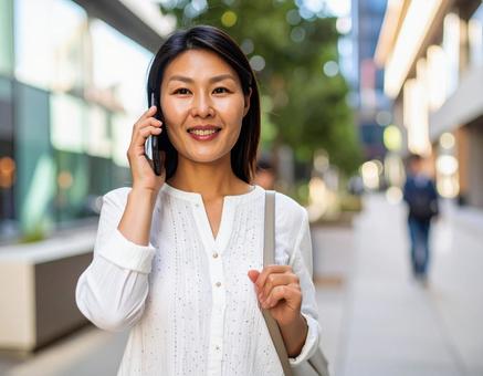 街中で電話をかける女性の写真