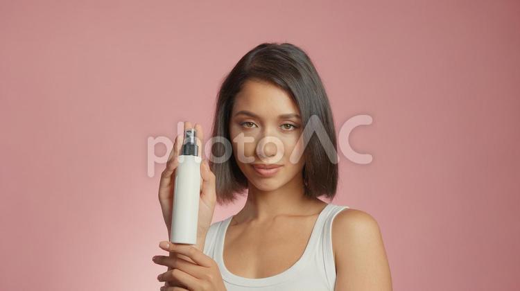 スプレーボトルを持ってカメラ目線の女性 女性,外国人,アジア人の写真素材
