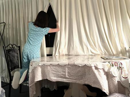 部屋の中から窓の外を覗く女の子 後ろ姿,パジャマ,窓の外の写真素材