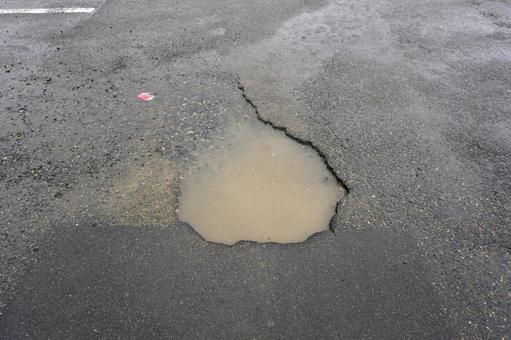 アスファルトに開いた穴（雨）01 アスファルト,道路,駐車場の写真素材