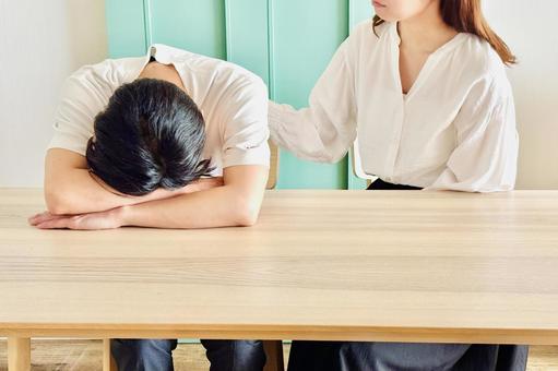 家のリビングで悩む男性を励ます女性 家のリビングで悩む男性を励ます女性 励ます,悩む,夫婦の写真素材