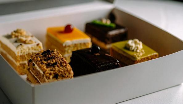 持ち帰りの箱に入ったケーキの詰め合わせ 持ち帰りの箱に入ったケーキの詰め合わせの写真