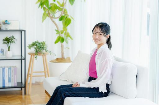 リビングでくつろぐ若い女性 若い女性,笑顔,大学生の写真素材