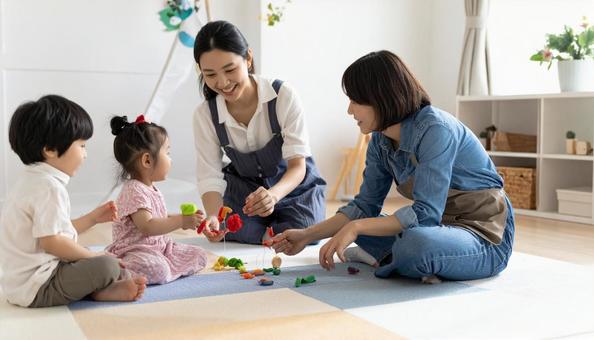 人形で遊ぶ園児と先生の写真