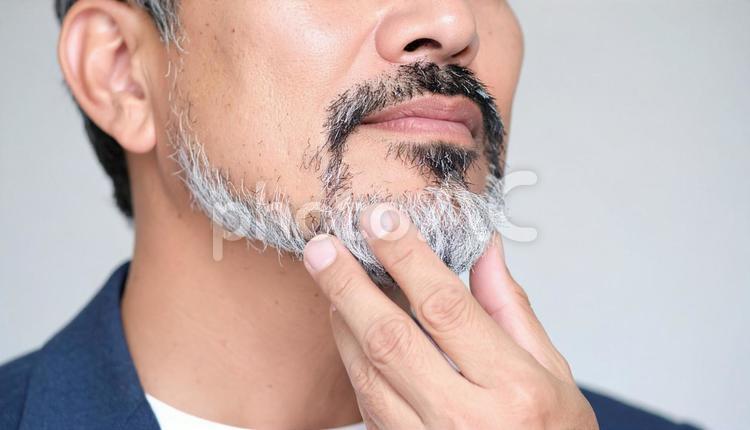 白髪の混じる髭を触るミドル男性の口元 メンズビューティ,ビューティー,ボディパーツの写真素材