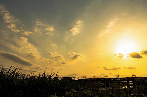 夕日に照らされた土手と河川敷の土手 夕焼け,夕日,夕暮れの写真素材