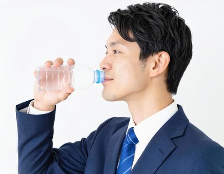 ペットボトルの水を飲むビジネスマン ペットボトルの水を飲むビジネスマンの写真
