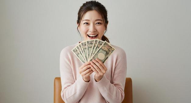 お札を手にして喜ぶ女性 お札を手にして喜ぶ女性の写真
