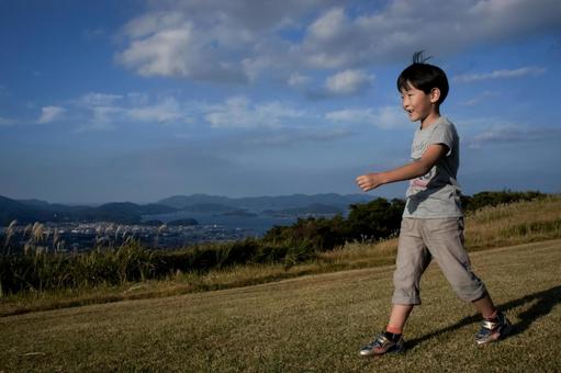 ＜素材＞家族旅行で秋の山頂に登る男の子 子供,山登り,空の写真素材