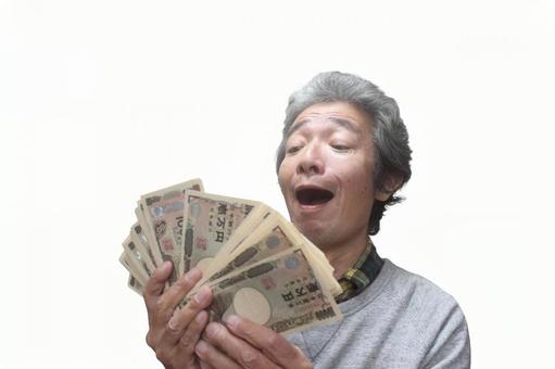 大金を持つシニア男性 シニア,シニア男性,シニアサラリーマンの写真素材