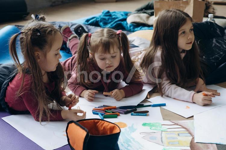 寝転んでお絵描きする女の子たち 女の子,人物,貧困の写真素材