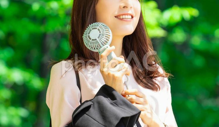 ハンディファンで涼む女性・熱中症対策 女性,夏,暑いの写真素材