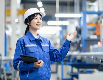 工場で案内する女性作業員の笑顔とプロ意識 工場で案内する女性作業員の笑顔とプロ意識の写真