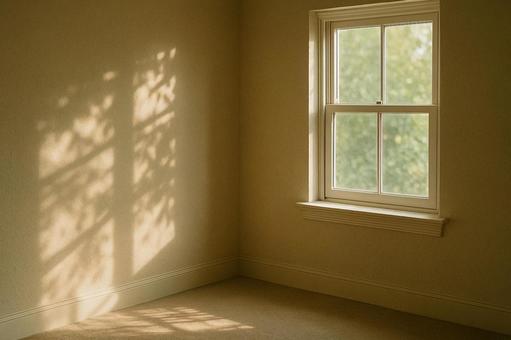木漏れ日が映る窓際の壁の写真