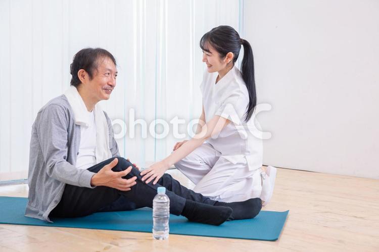 足が痛い中高年男性と白衣の女性 整形外科,作業療法士,理学療法士の写真素材