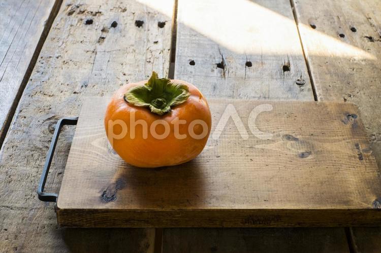 柿の実と木目美しいまな板 柿,カキ,甘柿の写真素材