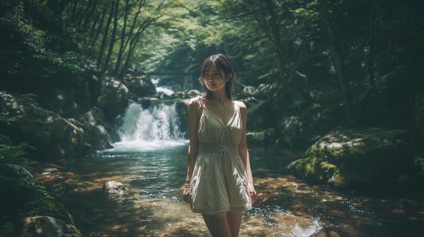 夏の深緑と渓流沿いの遊歩道と若い女性の写真