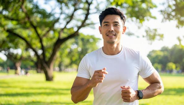 公園でジョギングをする笑顔の日本人男性 公園でジョギングをする笑顔の日本人男性の写真