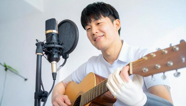 義手の若者がギターを弾く 義手の若者がギターを弾くの写真