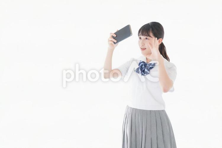 スマホを使う制服姿の女子学生 投稿,入金,電波の写真素材