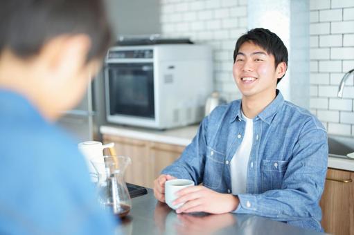 笑顔でコーヒーを飲む男性と向かいあっている男の子の後ろ姿 笑顔でコーヒーを飲む男性と向かいあっている男の子の後ろ姿 親子,男の子,コーヒーの写真素材