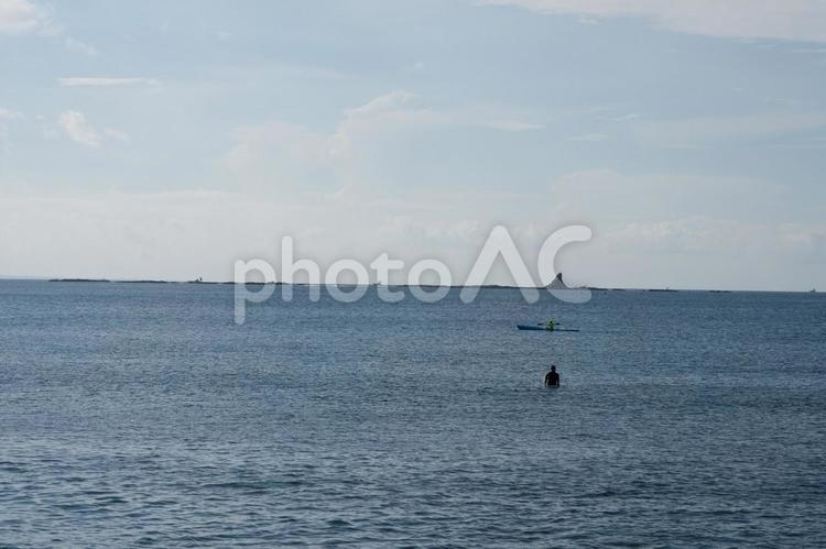 起きを泳ぐサーファーと烏帽子岩 青空,海岸,砂浜の写真素材