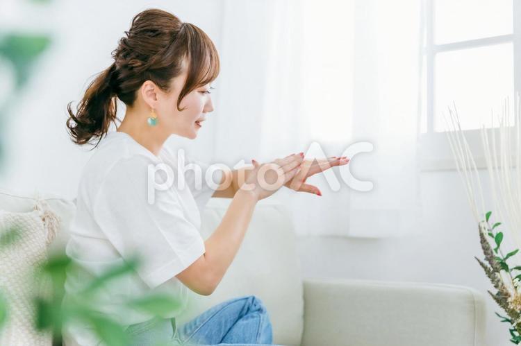 手の甲にハンドクリームを塗る日本人女性 ハンドクリーム,ハンドケア,あかぎれの写真素材