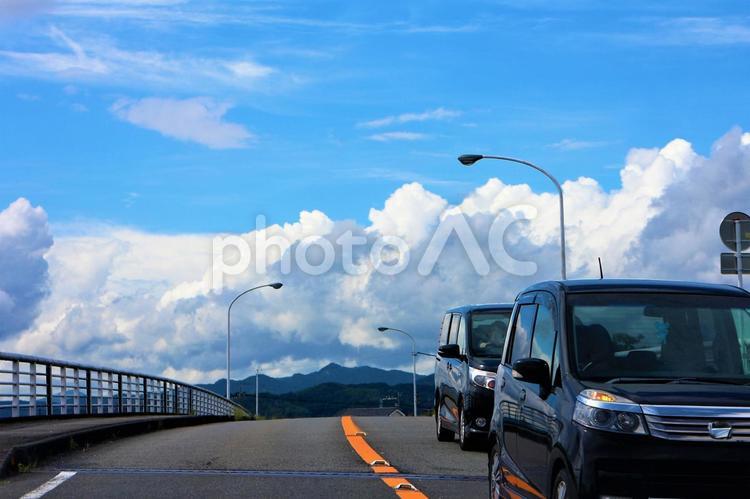 もくもくと盛り上がる雲と橋を通る車 雲,もくもく,白いの写真素材