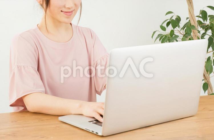 ノートパソコンを笑顔で使う女性 副業,ショッピング,ネットショッピングの写真素材