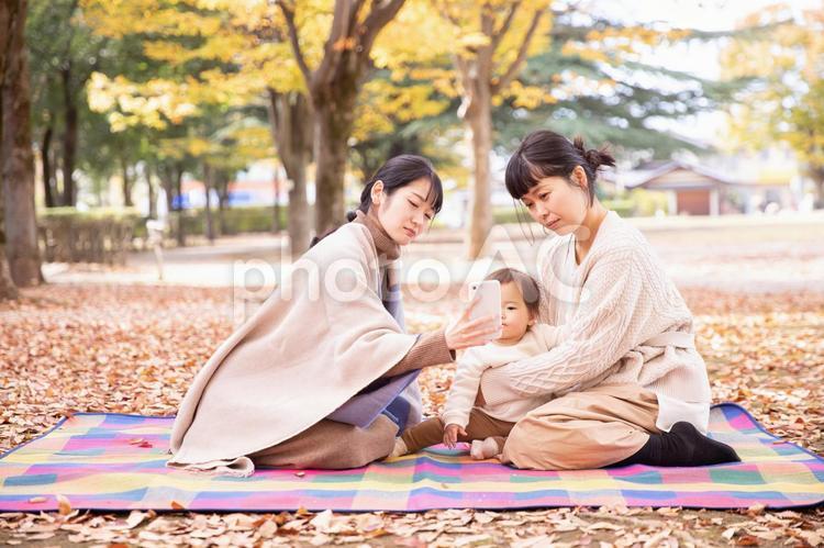 公園でママ友と話す女性（困る） ママ友,アプリ,スマホの写真素材
