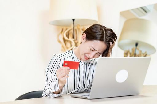 カードをもち頭を抑える女性 カードをもち頭を抑える女性 オンライン決済,クレジットカード,支払いの写真素材