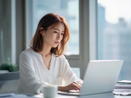 オフィスでPC作業する女性 オフィスでPC作業する女性の写真