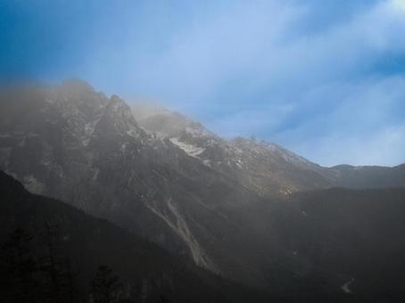 霧がかかる岩山と青空が広がる神秘的な風景 霧がかかる岩山と青空が広がる神秘的な風景の写真