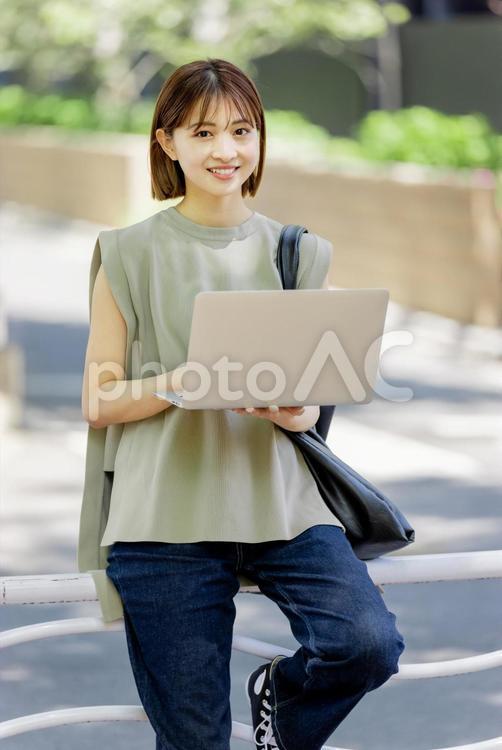 新緑の中ノートパソコンを使う女子大生 女性,人物,ノートパソコンの写真素材