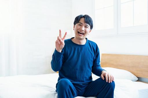 ピースするパジャマ姿の男性 ピースするパジャマ姿の男性 快眠,すっきり,がんばるの写真素材