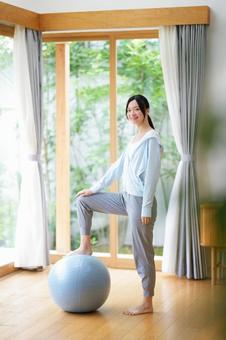 バランスボールに片足を乗せカメラ目線の女性 女性,日本人,バランスボールの写真素材