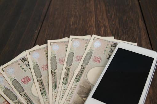 スマホと千円札の並び スマホと千円札の並びの写真