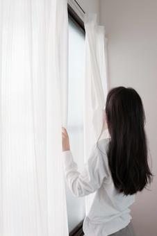 白いカーテンを開ける女性 白いカーテンを開ける女性 カーテン,女性,後ろ姿の写真素材