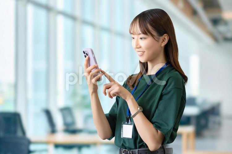 スマホを使う笑顔の女性・ビジネスウーマン 女性,スマホ,笑顔の写真素材