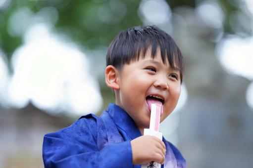 千歳飴を嬉しそうになめる袴姿の男の子 千歳飴を嬉しそうになめる袴姿の男の子 七五三,お参り,七五三参りの写真素材