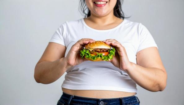 ハンバーガーを持つ太った日本人女性 ハンバーガーを持つ太った日本人女性の写真