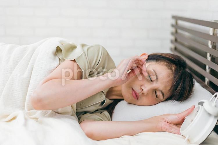 寝坊するミドル世代の女性（眠い） 遅刻,目覚め,寝起きの写真素材