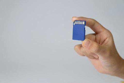 青いSDカードを持つ手 sdカード,メモリカード,フラッシュメモリの写真素材