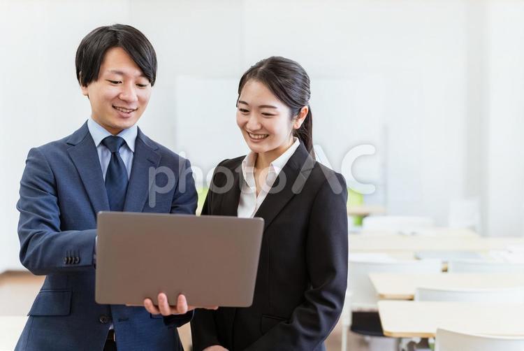 スーツを着たパソコンを使う正社員の男女 ビジネスマン,ビジネスウーマン,スーツの写真素材